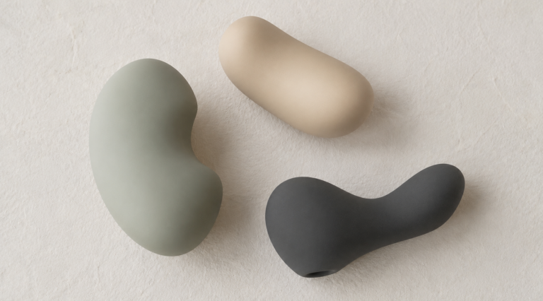 Three softly shaped vibrators in sage green, sand and charcoal, illustrating how to choose a first vibrator